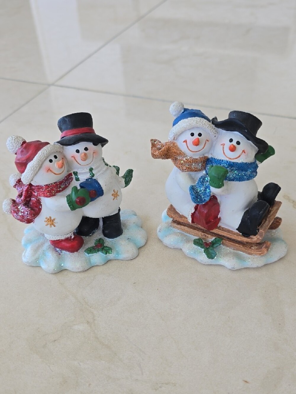 Festive Snowman Figurines in White and Blue - Sledding and Cuddling